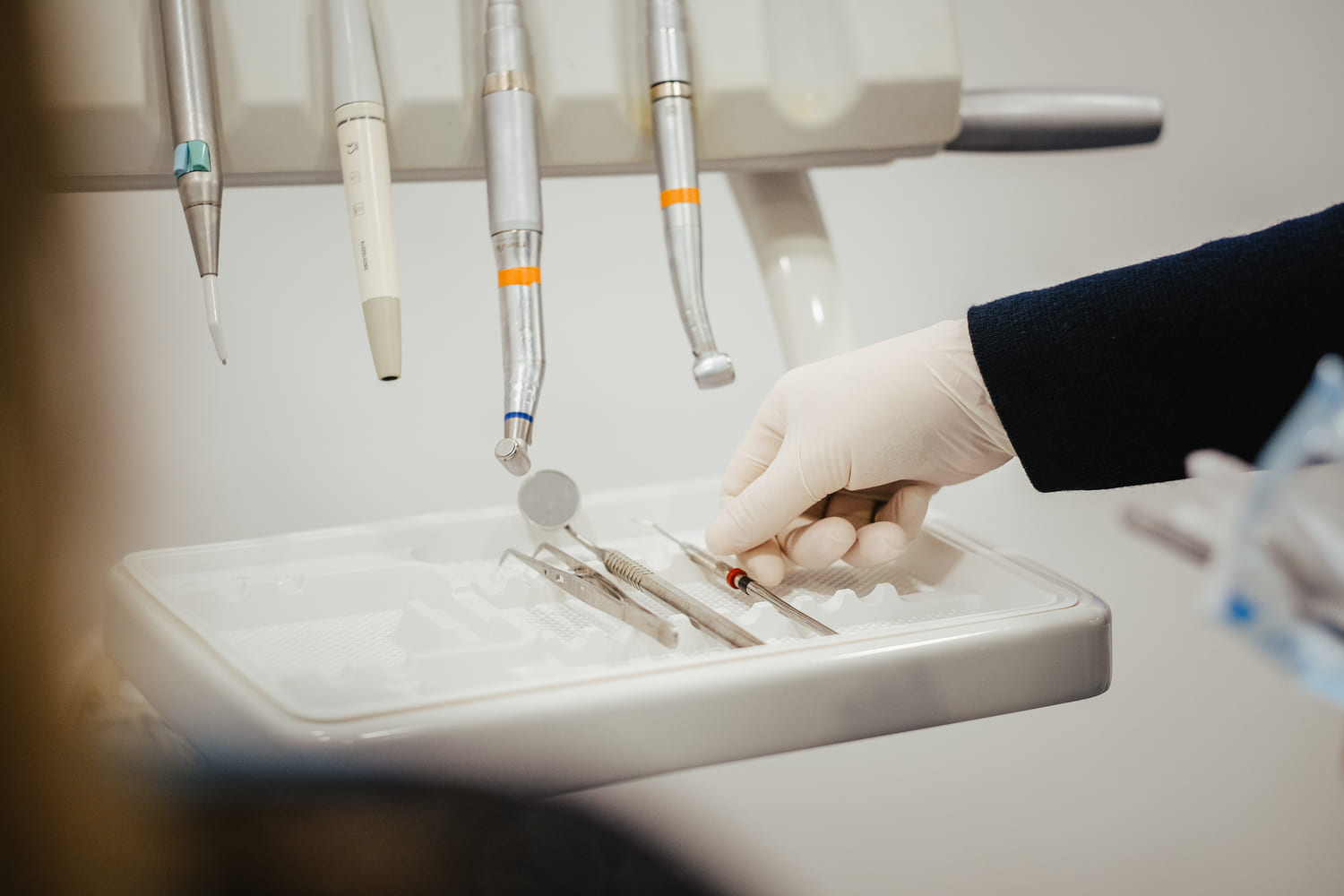 Una mano di un dentista che utiliza degli strumenti ben in ordine e allineati su un vassoio in Melamina di Larident